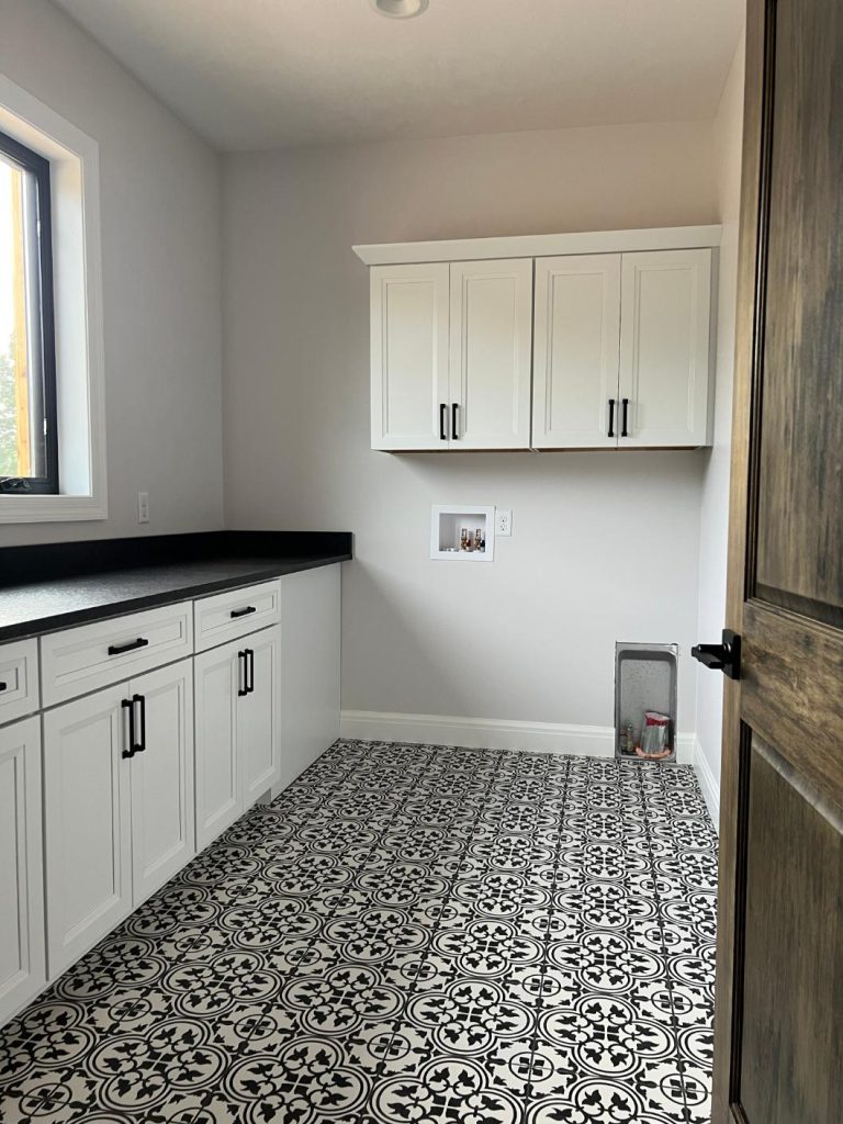 laundry room with decorative black and white tiled floor